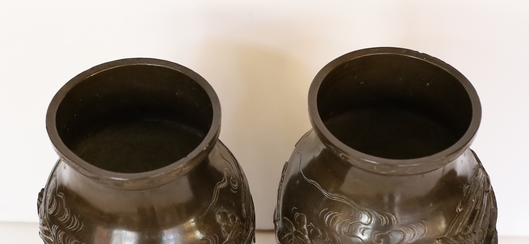 A pair of Japanese Meiji period bronze vases decorated in relief with phoenix, height 27cm